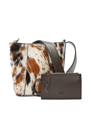 Mała torba typu bucket z wzorem skóry krowy w kolorach brązowym, czarnym i białym, szeroki, ciemnobrązowy pasek skórzany oraz dopasowana ciemnobrązowa saszetka na suwak.