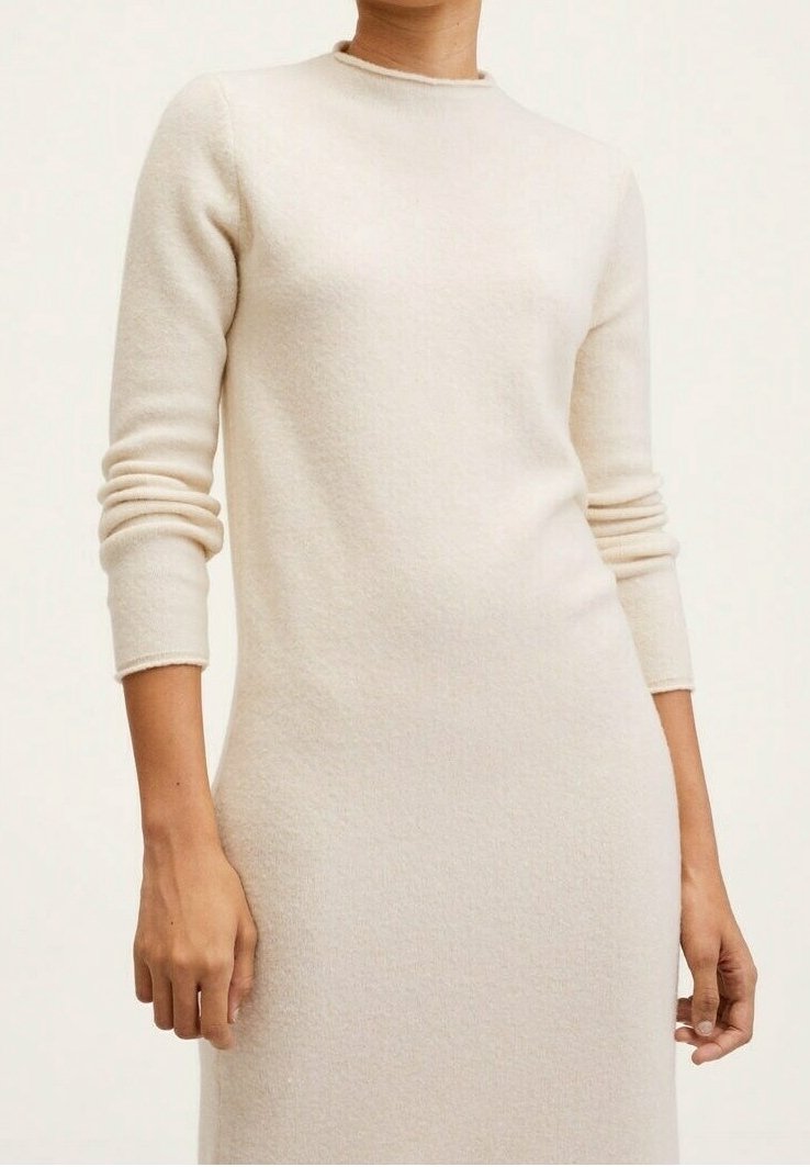 Robe en laine beige à manches longues, col rond et silhouette ajustée. Texture douce et accents côtelés aux poignets.