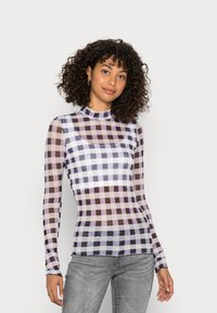Camisola de manga longa feita de material translúcido, apresentando um padrão xadrez em tons de roxo e bege, com gola alta e design ajustado.