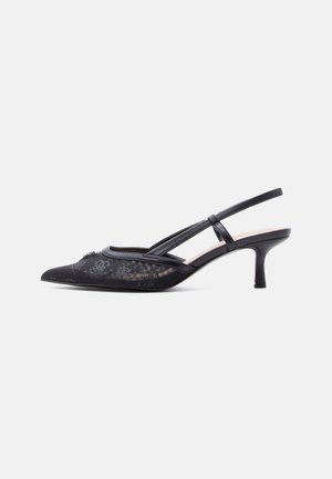 Schwarzer Slingback-Kitten-Heel mit spitzer Zehenpartie, Mesh-Obermaterial mit dezenten Totenkopf- und Blumenmustern sowie dünnen Riemen über dem Fuß.