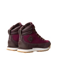 Stivali da trekking color bordeaux con accenti marroni, parte superiore in suede e tessuto, occhielli in metallo, collare imbottito e suola in gomma testurizzata per una maggiore aderenza.