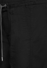 Svarta träningsshorts gjorda av lättviktsmaterial med resårmidja, med dragsko och sidofickor. Strukturerad yta.