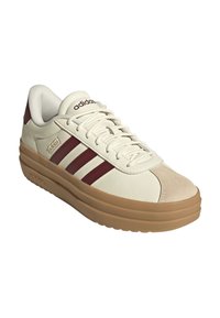 Sneaker bianca in pelle con dettagli bordeaux, tre strisce e punta in suede beige. Presenta suola in gomma e chiusura con lacci.