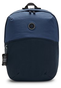 Two-tone navy blue backpack with rounded top, front zipper pocket, circular logo patch, and a small black keychain with a cartoon character.