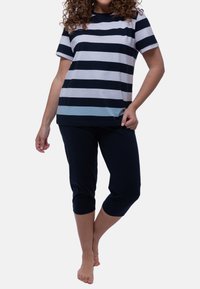 T-paita lyhyt hihoilla, jossa on tummansinisiä ja vaaleansinisiä raitoja, yhdistetty tummansinisiin capri-housuihin, jotka on valmistettu pehmeästä kankaasta ja joissa on rento istuvuus.