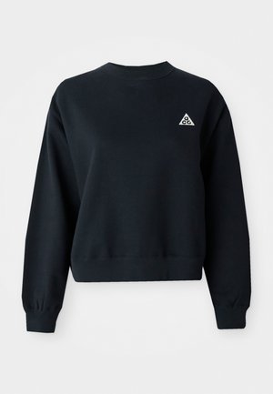 Schwarzer, kurzer Sweatshirt aus weichem Stoff. Hat einen Rundhalsausschnitt und gerippte Bündchen. Beinhaltet ein kleines, weißes Dreieck-Logo auf der linken Brust.