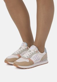 Sneakers bianchi e beige con texture in mesh e suede, dettagli in colori pastello, design con lacci e punta arrotondata.