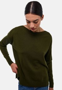 Pull en maille vert foncé avec un col bateau, manches longues et coupe décontractée. Poignets et ourlet côtelés, tissu texturé.