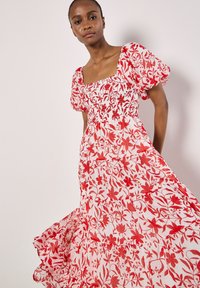 Maxikleid mit rotem Blumenmuster, Puffärmeln, quadratischem Ausschnitt und gerafftem Oberteil; leichtes Material mit gestuftem Saum und fließender Silhouette.