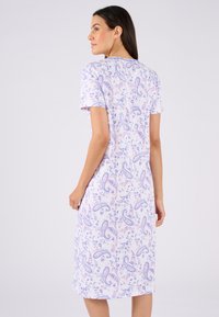 Abito a maniche corte di un leggero colore viola con un motivo paisley e floreale. Realizzato in tessuto morbido, presenta un taglio al ginocchio con una vestibilità ampia.