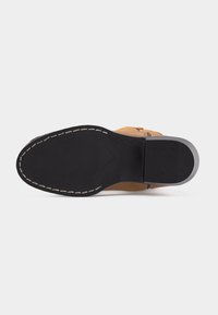 Σόλα ταμπά δερμάτινου επίσημου παπουτσιού με μαύρη ραμμένη εξωτερική σόλα και ελαστική φτέρνα, εμφανίζεται πάνω σε λευκό φόντο.