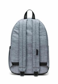 Sac à dos en tissu gris avec bretelles rembourrées, poignée supérieure et deux poches latérales. Présente un motif texturé et un design épuré et arrondi.