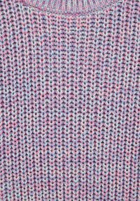 Acercamiento de hilo rosa, azul y blanco tejido en un patrón acanalado con puntadas verticales en forma de V.