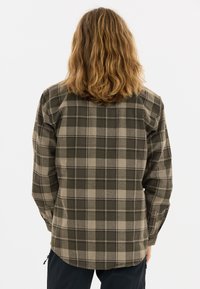 Groene en beige geruite flanellen shirt met een rechte snit, lange mouwen en een ronde zoom, met zichtbare stiksels en een zachte textuur.