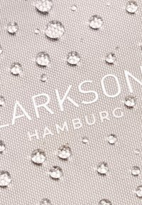 Ljusgrått texturerat tyg med vattendroppar och ett pr präglat vitt logotyp "CLARKSON HAMBURG" som är framträdande.