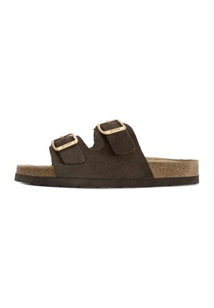 Brązowy zamszowy sandał na płaskiej podeszwie z dwoma regulowanymi metalowymi klamrami i korkową wkładką, na białym tle.