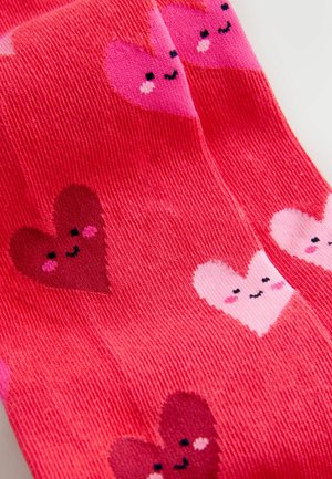 Rosa Socken mit geripptem Muster, verziert mit verspielten Herzmustern in Dunkelrot und Hellrosa, jeweils mit einem lächelnden Gesicht als Detail.