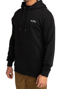 Sudadera negra con capucha hecha de un tejido suave, que cuenta con un bolsillo canguro, cordones, y un logotipo blanco en el pecho, con puños y dobladillo acanalados.