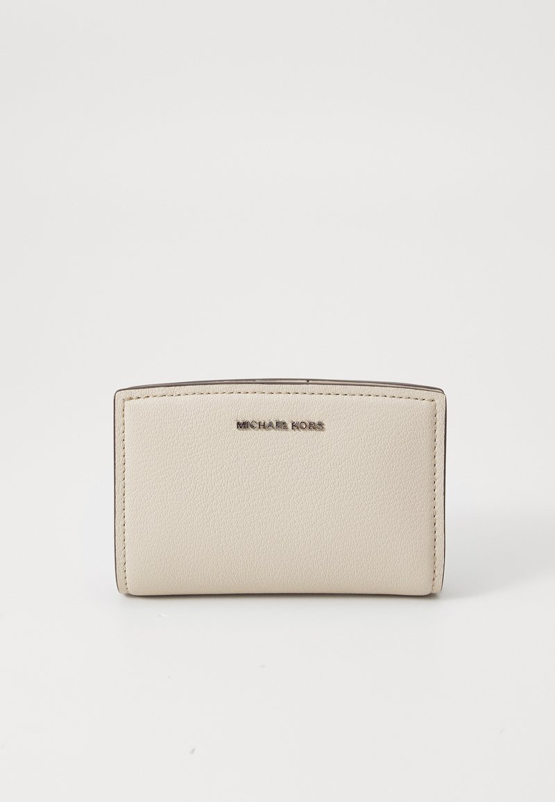 Portafoglio in pelle beige con parte superiore arrotondata, logo "MICHAEL KORS" impresso e cuciture visibili lungo i bordi. Texture liscia, design compatto.