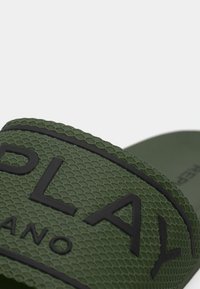 Πράσινο λαστιχένιο σανδάλι με λουράκι με υφή που φέρει ανάγλυφο λογότυπο "PLAY" και λείο, καμπυλωτό πέλμα.