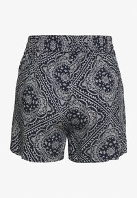 Shorts navy avec un motif bandana blanc, taille élastique et coupe ample. Conçus pour le confort avec une texture douce.