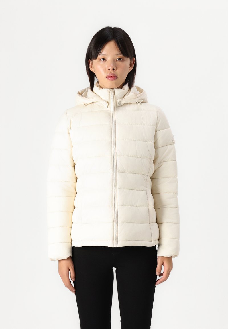 Giacca piumino color crema con chiusura a zip e cappuccio regolabile. Presenta cuciture orizzontali e una texture leggermente lucida.