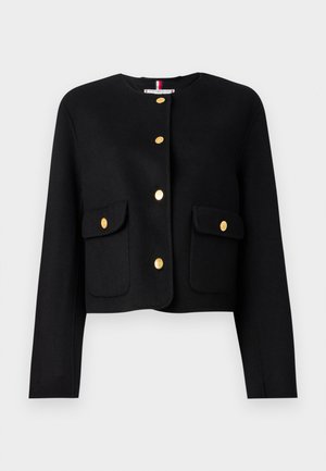 Veste noire courte à manches longues, dotée de boutons dorés et de deux poches avant. Texture lisse et col rond.