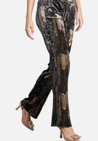 Pantaloni di velluto neri e bronzo con un motivo in pelle di serpente, svasati in fondo, caratterizzati da una texture lucida e una vestibilità morbida.