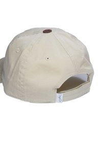 Beige Baumwollmütze mit runder Krone, verstellbarem Riemen und braunem Knopf oben. Verfügt über Belüftungslöcher und ein kleines Markenetikett an der Seite.