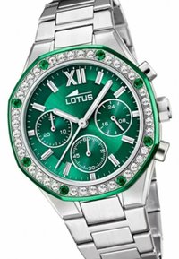 Orologio in metallo argento con quadrante ottagonale verde, accenti argentati, tre sottodial, lunetta incastonata di cristalli e dettagli in pietre verdi.