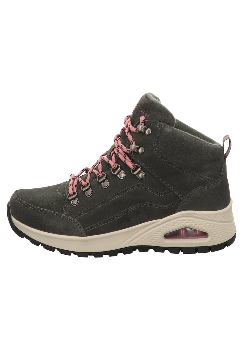 Botas de senderismo de ante gris con cordones rosas, ojetes de metal y suela acolchada con una unidad de aire visible. Suela de goma texturada para mayor agarre.