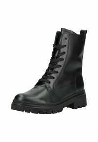Bottine de combat en cuir noir avec lacets, semelle à crans épais et languette à l'arrière, légèrement inclinée vers la droite sur fond blanc.