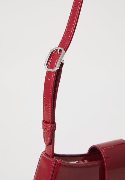 Curea de mână din piele sintetică roșie cu un aspect lucios, dotată cu elemente metalice de culoare argintie și o cataramă ajustabilă, evidențiind o textură netedă și un design elegant.