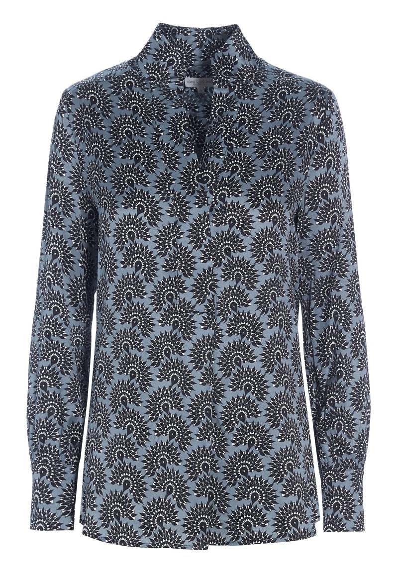 Blouse boutonnée à manches longues avec un motif floral circulaire bleu foncé et blanc sur fond bleu clair.