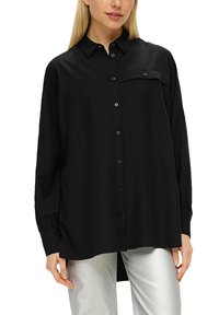 Schwarzes Langarmshirt mit Knopfverschluss, einer einzelnen Brusttasche und lockerer Passform. Hergestellt aus glattem, leichtem Stoff.