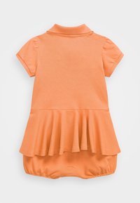 Krátké šaty v oranžové barvě, s polo límečkem a volánkovým lemem, vyrobené z texturované látky, s těsným střihem na spodní části.
