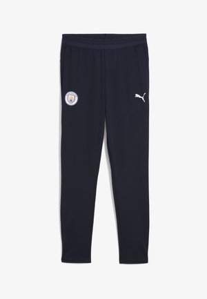 Marineblauwe sportbroeken met een Manchester City-logo en een wit Puma-embleem aan de zijkant, ontworpen voor sport en casual gebruik.