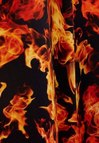 Flammönstrad tyg med livliga orange och gula nyanser mot en svart bakgrund; slät textur med virvlande eldiga mönster.