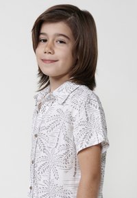 Trumpas rankovėmis mygtukinis marškiniai iš lengvos medžiagos su baltu pagrindu ir pilku lapų raštu. Yra klasikinis apykaklė ir mediniai mygtukai.