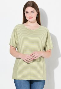 Camiseta verde a rayas con cuello redondo y mangas cortas, hecha de tela suave. Acompañada de unos pantalones vaqueros de denim azul.