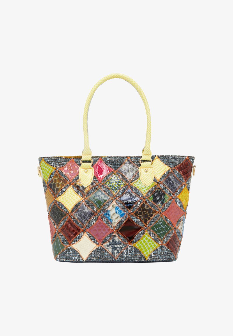 Multifarvet patchwork tote taske lavet af forskellige teksturerede materialer, med et vævet gult håndtag og dekorativ syning.