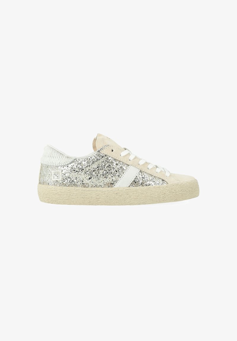 Sneakers med en glitrende sølv overdel, hvide accenter og en beige gummisål. Har en tekstureret bagside og flade snørebånd.