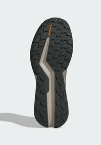 Svart gummi yttersula med djupa mönster för bra grepp, med en grå mellansula och en framträdande Continental-logotyp. Platt, rundad tådesign.