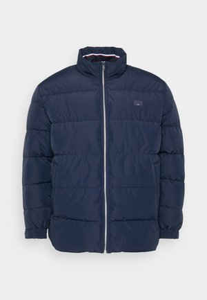Giacca imbottita blu navy con colletto alto, chiusura con zip e motivo a righe orizzontali. Presenta polsini elasticizzati e un piccolo dettaglio del logo.