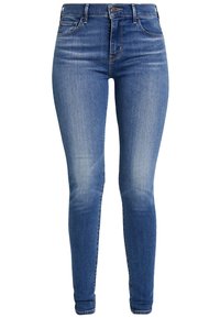 Högmidjade skinny jeans i mörkblå denim, med en urtvättad finish, fem fickor och en knappstängning fram.