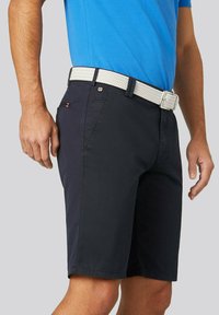 Shorts navy en matériau léger, avec une coupe slim, des poches avant et une ceinture tressée blanche texturée.