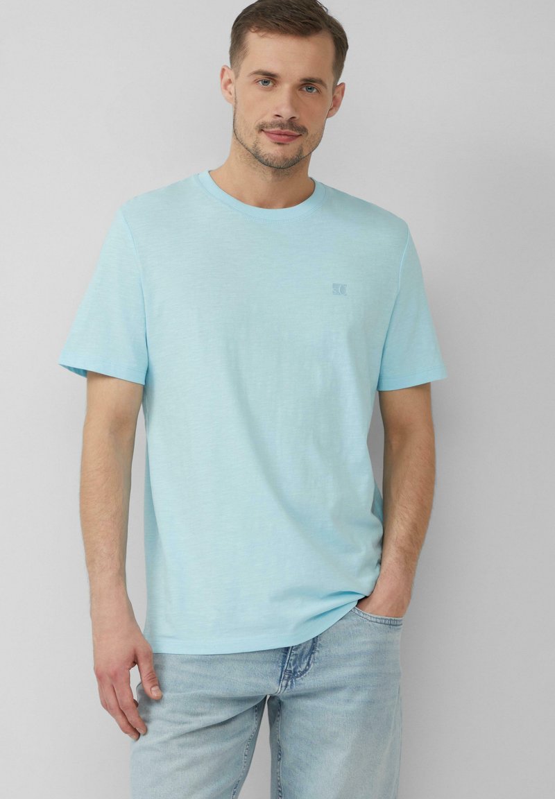 Jasnoniebieska bawełniana koszulka z okrągłym dekoltem i krótkimi rękawami, z małym logo na piersi i luźnym krojem.