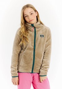 Beige fleece jas met hoge kraag en teal rits. Heeft zijzakken en een logo patch. Zachte textuur met een snug fit.