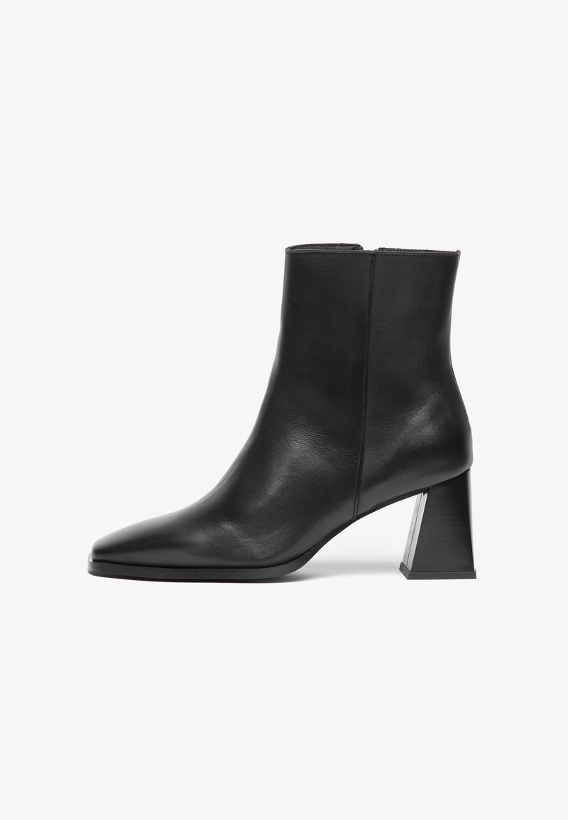 Sorte skinn ankle boot med spiss tå, medium geometrisk hæl, og en glatt tekstur. Enkelt design uten synlig maskinvare eller aksenter.
