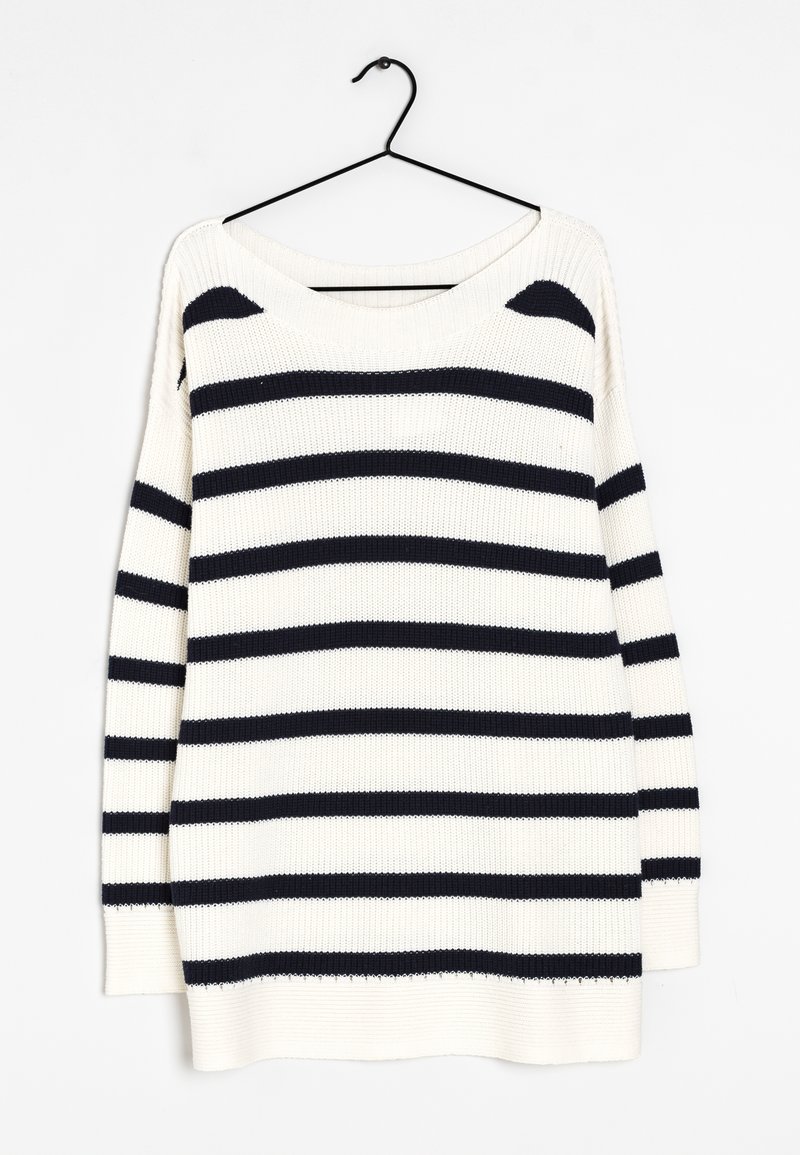 Pull blanc en tricot avec des rayures horizontales noires suspendu à un cintre noir sur un fond blanc.